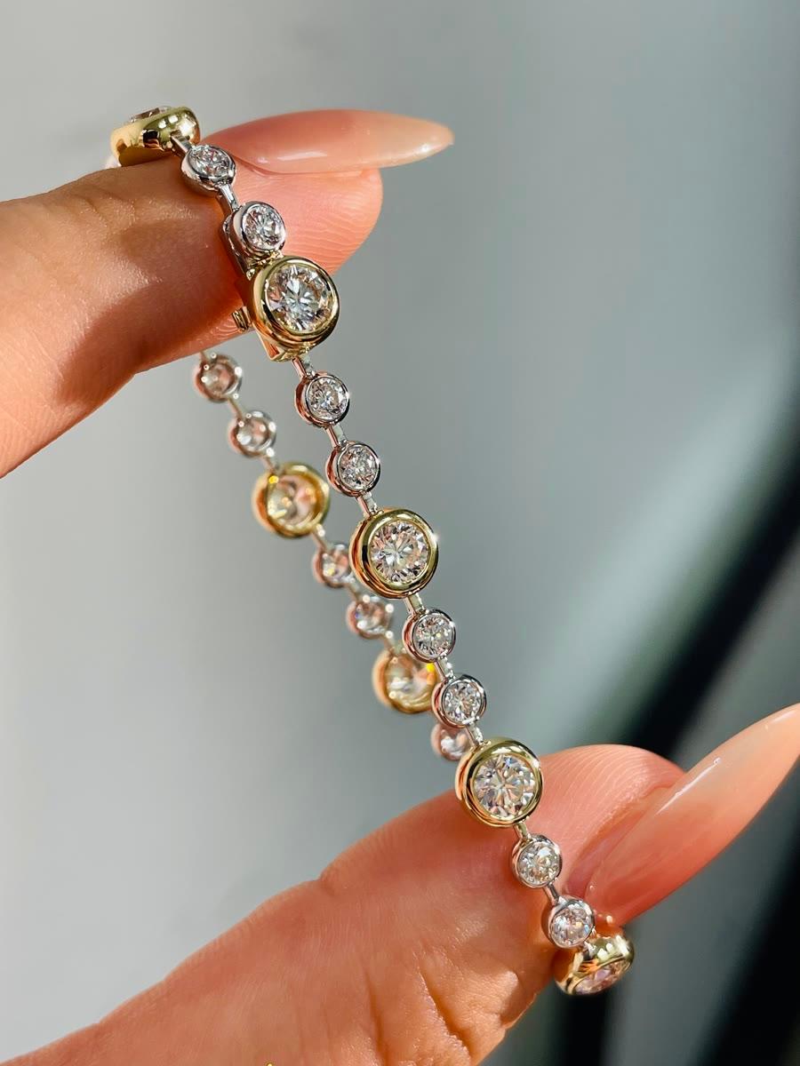 A finished gold tennis bracelet set with bezel-set round diamonds